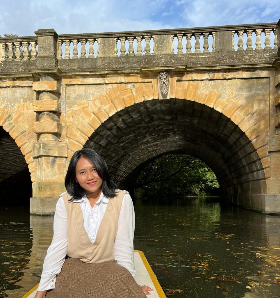 Image of Genia Fernanda on a boat in front of a bridge