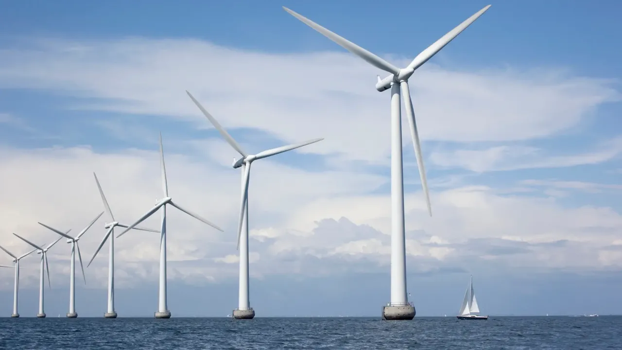 Wind turbines with a sailboat behind