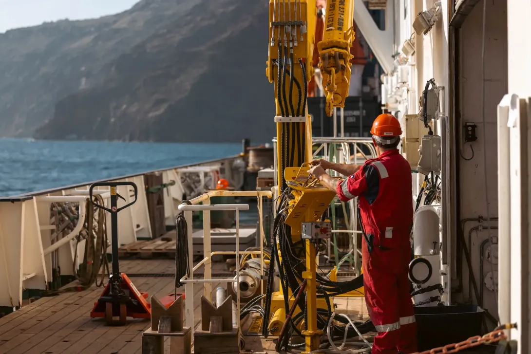 The crane on RRS Discovery being operated by a crew member