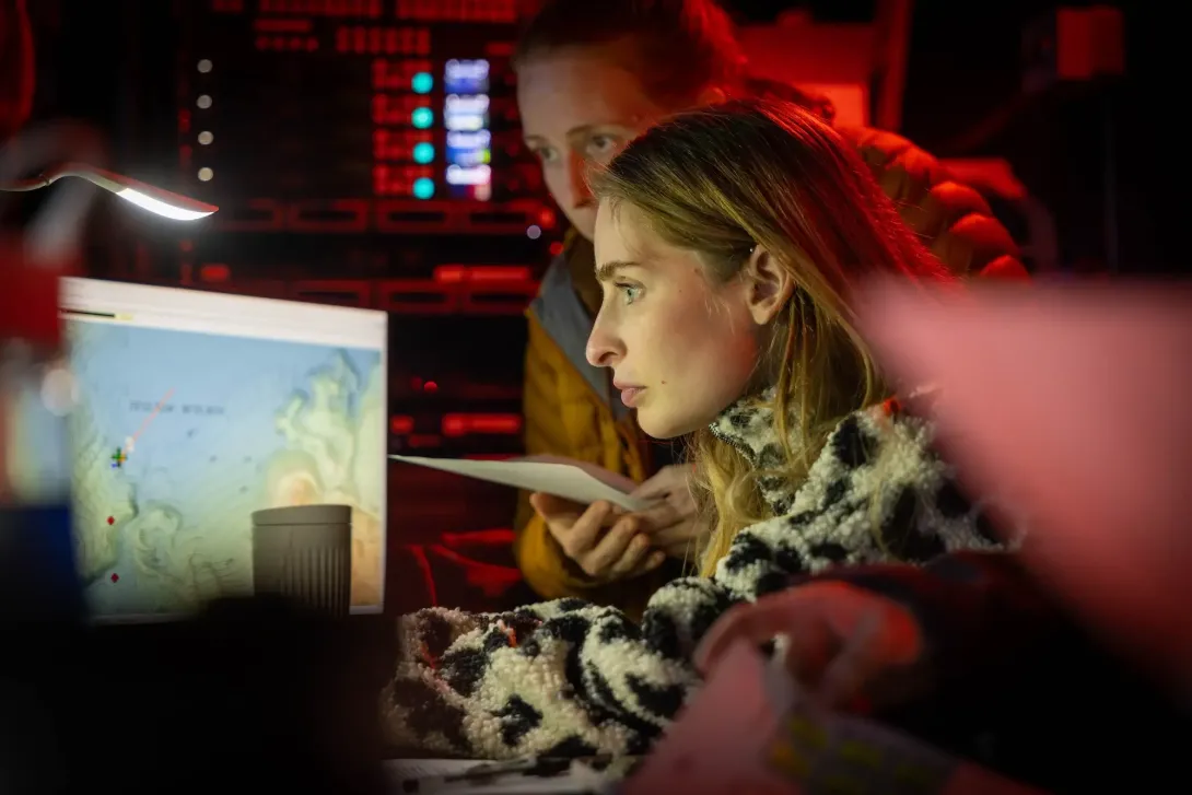 Scientists studying maps in the ROV control room