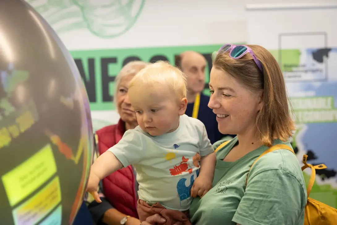 Family interacting with the 'Ocean's Crystal Ball'